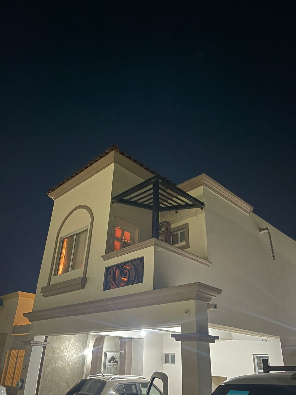 Fachada residencial con pérgola iluminada y herrería en Hermosillo